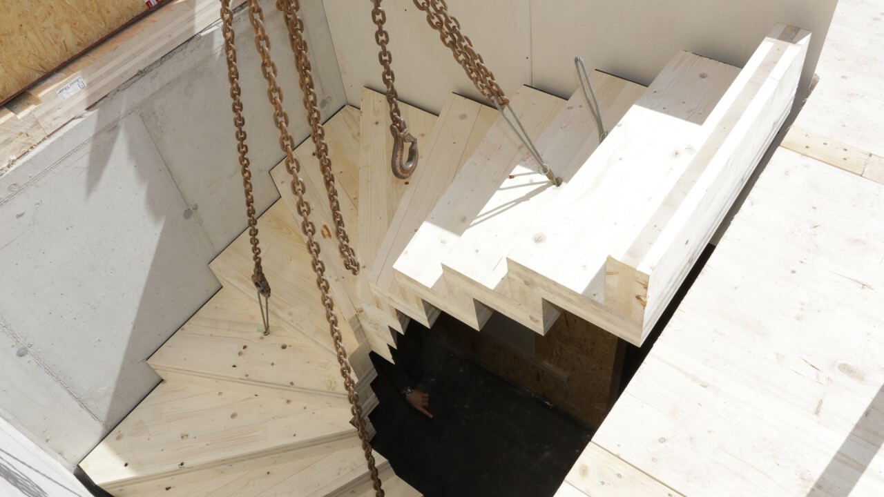 Die Fertig-Treppe aus Brettsperrholz wird mit dem Kran eingehoben