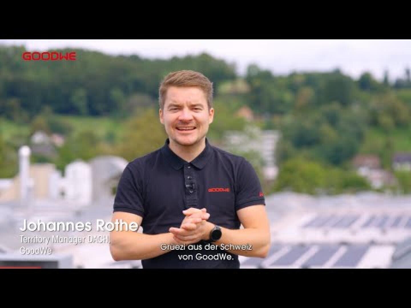A man in a black GoodWe polo shirt stands outdoors with his hands clasped, smiling at the camera. Text on the image identifies him as Johannes Rothe, Territory Manager DACH at GoodWe. A scenic, green landscape is in the background.