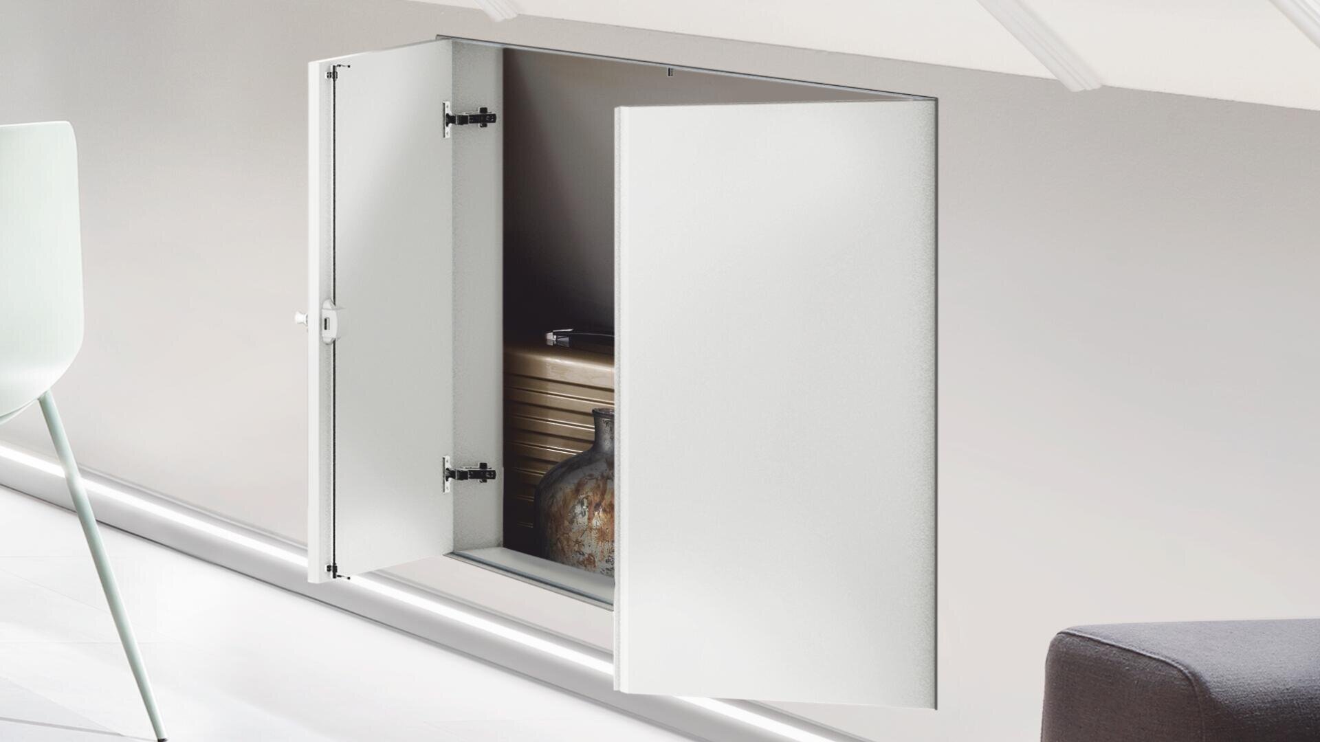 Ein kleiner weißer Schrank, der in eine Wand eingebaut ist, ist geöffnet und gibt den Blick frei auf Regale mit einem Stapel von Tabletts und einer dekorativen Vase darin. In der Nähe sind ein weißer Stuhl und ein Teil eines grauen Sofas zu sehen.