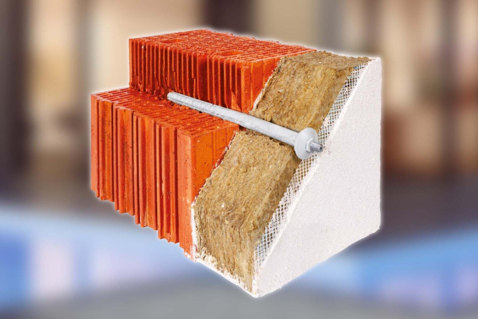 Ein Querschnitt einer isolierten Wand, der eine rote Ziegelschicht, eine Schicht aus gelbem Isoliermaterial, ein Netz und eine äußere Schicht aus weißem Gips oder Stuck mit einem eingesetzten metallischen Ankerbolzen zeigt.