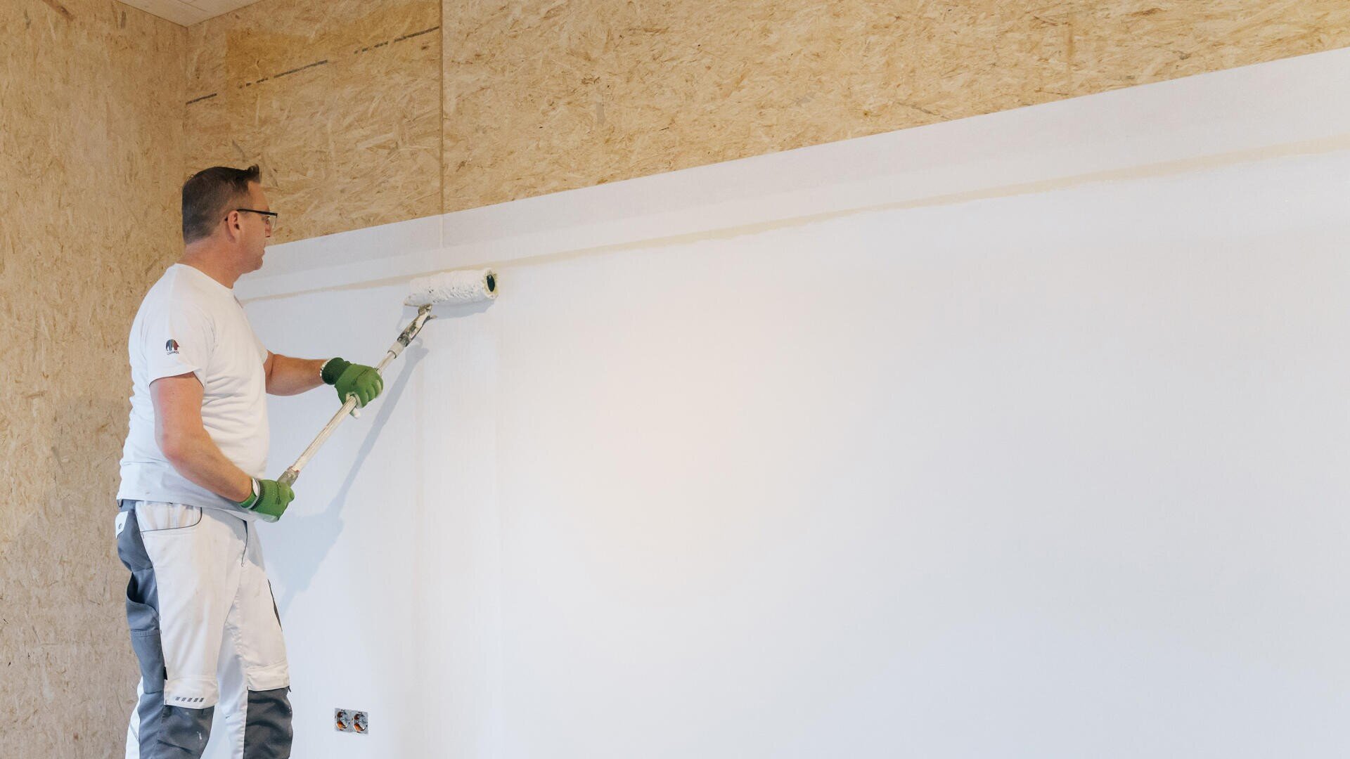 A person coated a MAGNUMBOARD® OSB Evolution-wall.