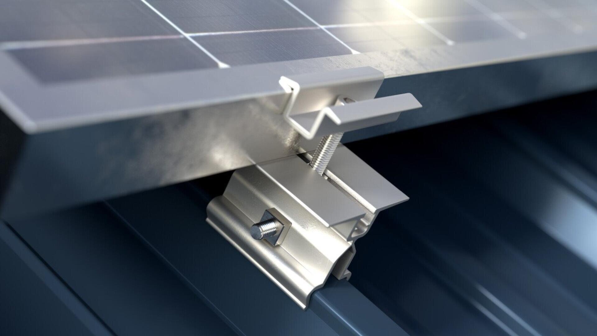 Close-up of a metal clamp securing a solar panel to a ribbed metal roof, showing detailed components including a bolt, screw, and bracket for mounting stability.