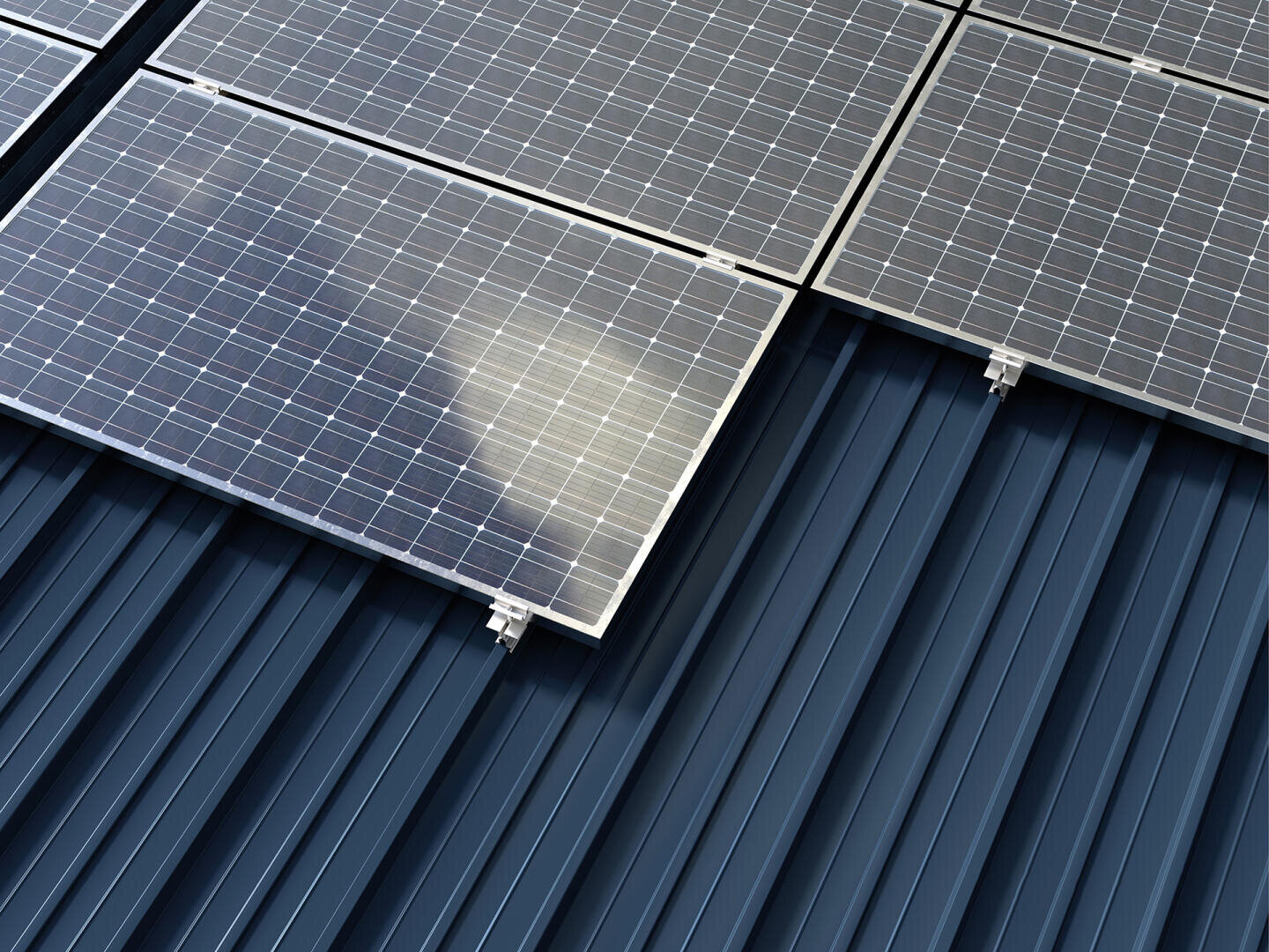 Nahaufnahme von Solarmodulen auf einem blauen Metalldach, die das Sonnenlicht reflektieren. Die Paneele sind in ordentlichen Reihen entlang des Daches angeordnet und unterstreichen die nachhaltige Energietechnologie.