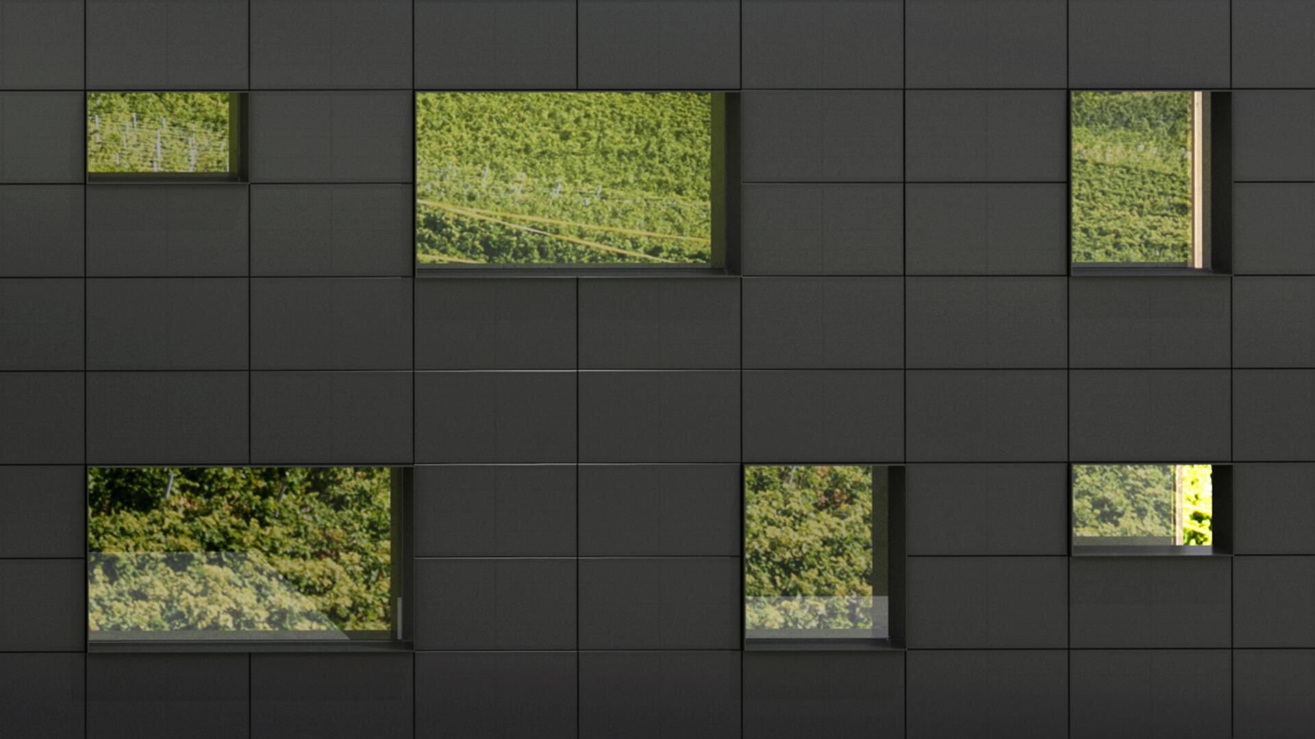 Eine dunkelgrau gekachelte Gebäudefassade mit sechs rechteckigen Fenstern, in denen sich grüne Bäume und Laub spiegeln.