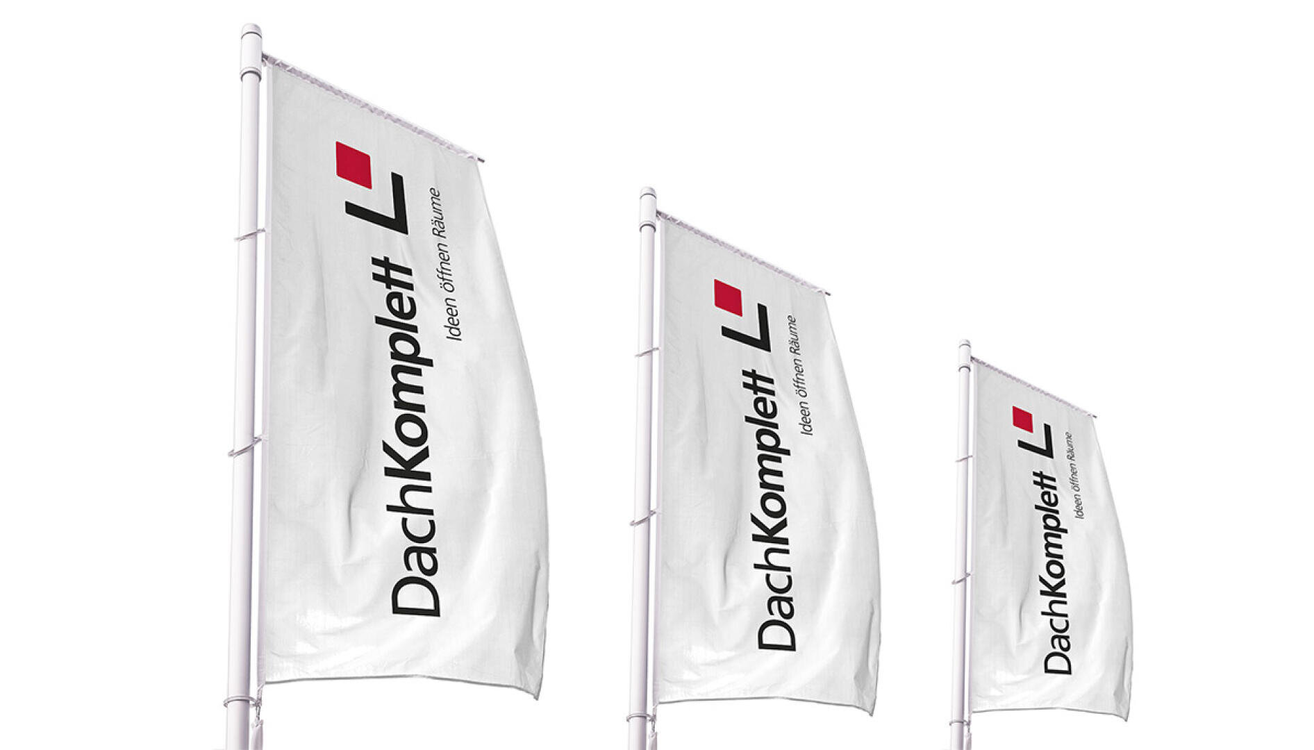 Drei hohe weiße Fahnen mit dem DachKomplett-Logo, einem roten Quadrat und schwarzem Text in deutscher Sprache, die auf Fahnenmasten vor weißem Hintergrund angebracht sind.