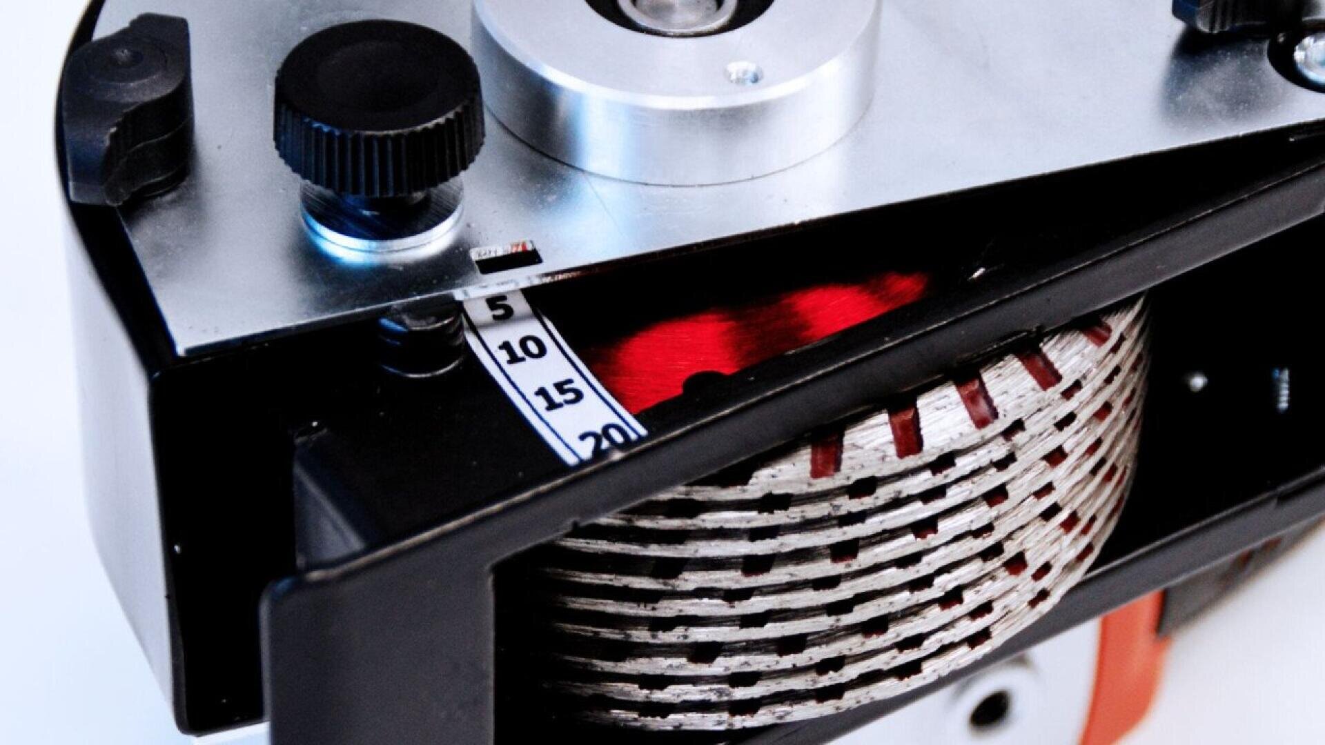 Close-up of a vintage film camera showing the film reel inside, a numbered frame counter, and mechanical dials on a metallic and black casing.