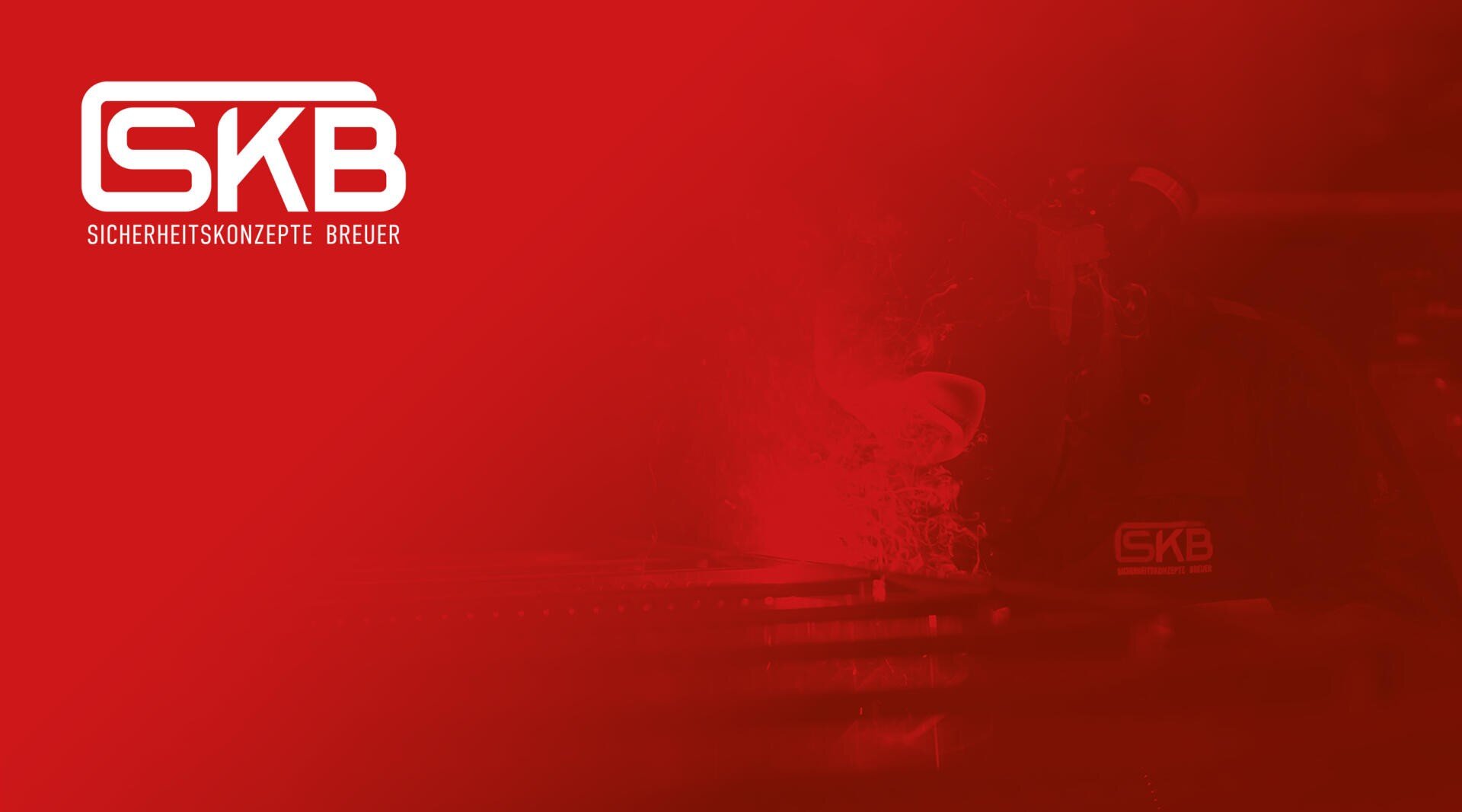 Ein rot eingefärbtes Bild mit dem SKB-Logo und dem Text Sicherheitskonzepte Breuer auf der linken Seite. Rechts ist eine Person in SKB-Uniform beim Schweißen zu sehen, mit sichtbaren Funken und Schweißgeräten.