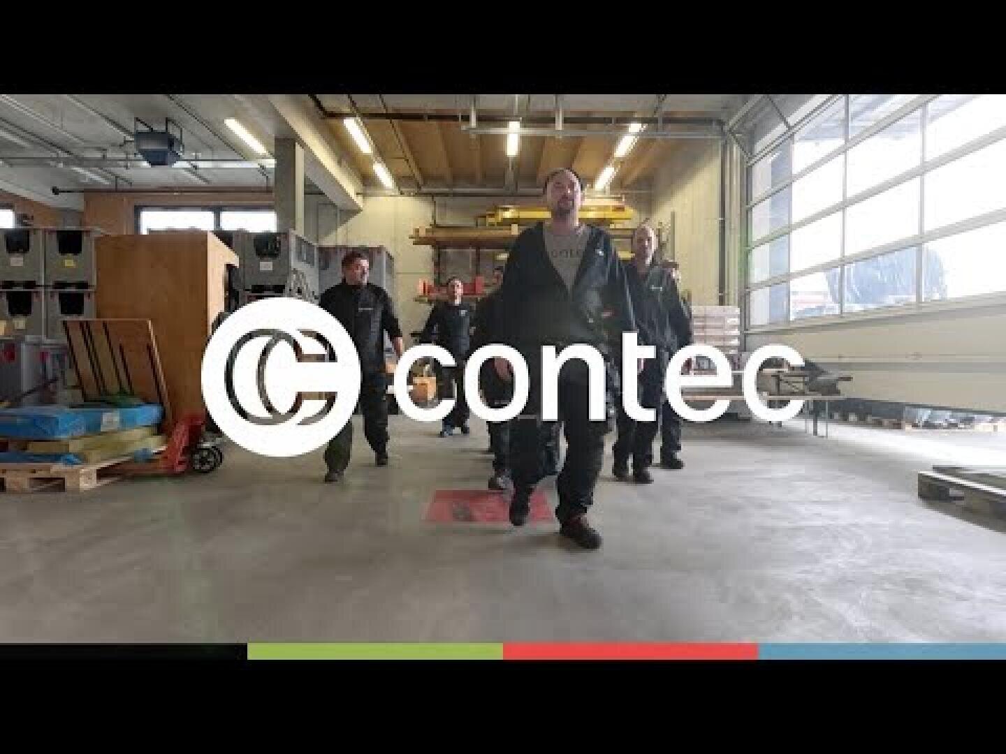 A group of people in work uniforms walk through a spacious, well-lit industrial hall. The lettering contec and the company logo are clearly visible above the picture.