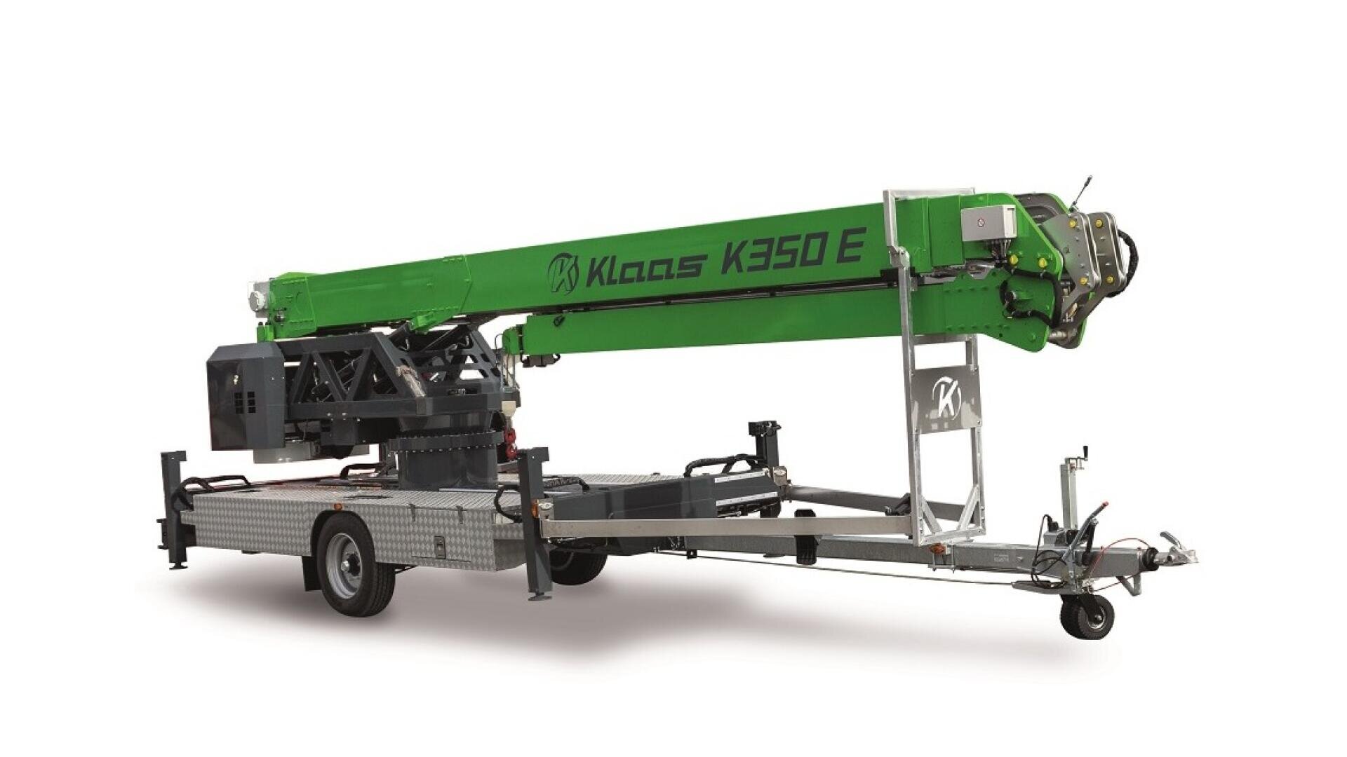 A green Klaas K350 E mobile crane mounted on a silver trailer with wheels, featuring an extended telescopic boom arm and stabilizing supports.