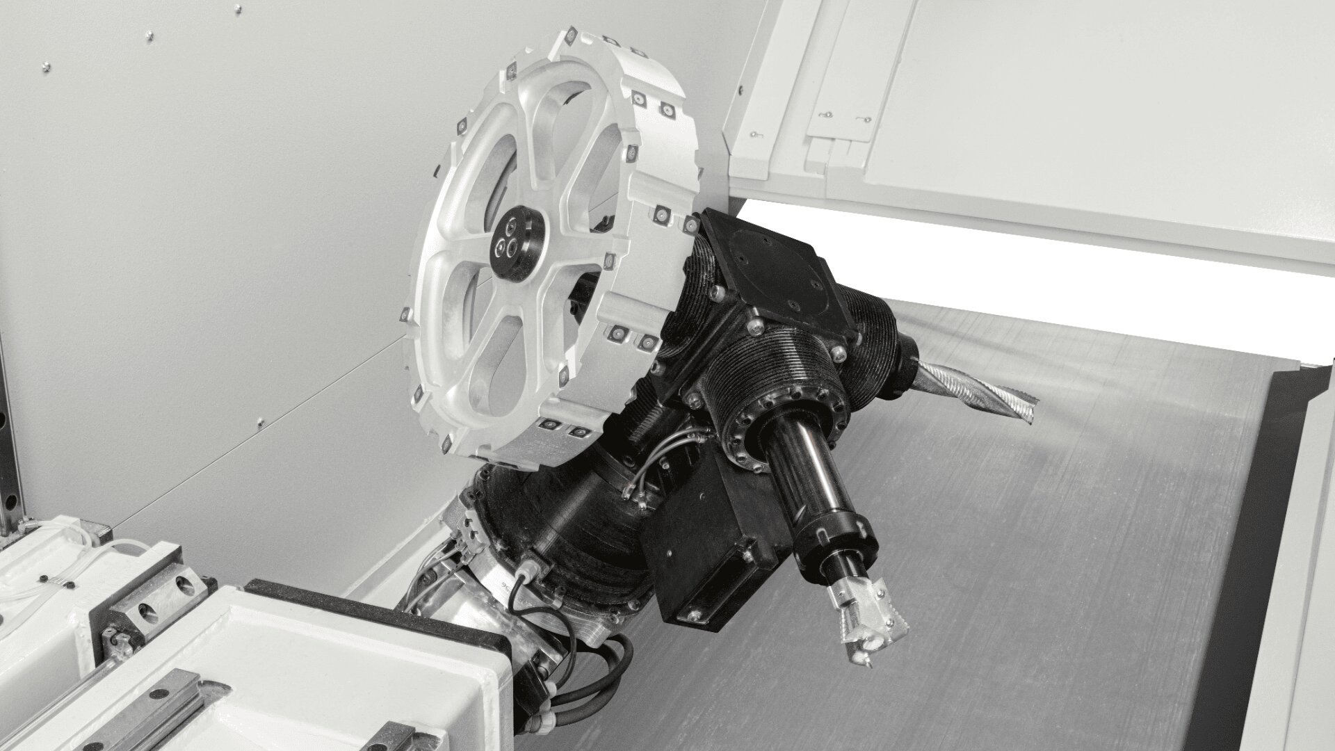 Nahaufnahme eines CNC-Werkzeugmaschinenhalters mit rotierender Spindel und angebrachtem Schneidwerkzeug in einem sauberen Industriegehäuse.