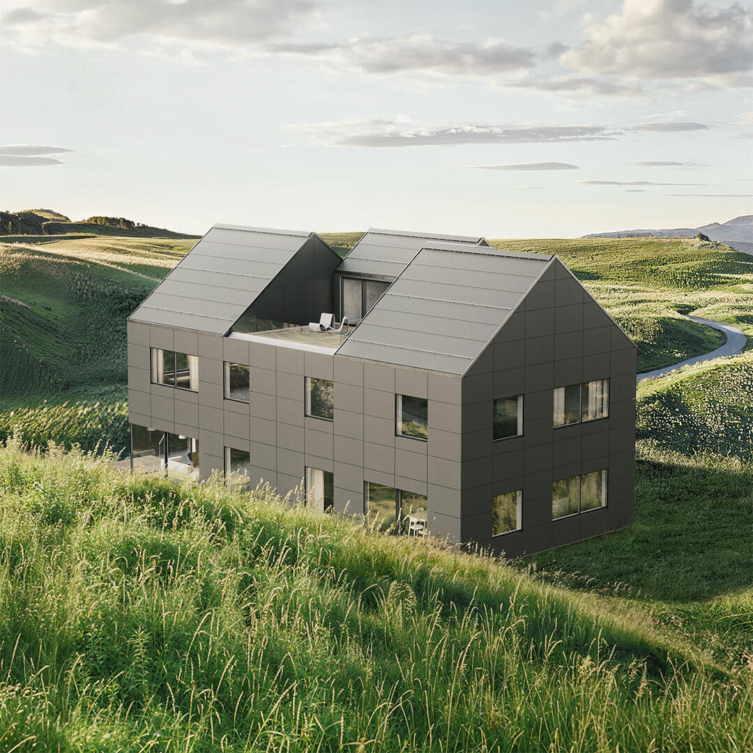 Ein modernes, dunkelgraues Haus mit geometrischem Muster steht auf einem grasbewachsenen Hügel, umgeben von einer sanften grünen Landschaft unter einem teilweise bewölkten Himmel.