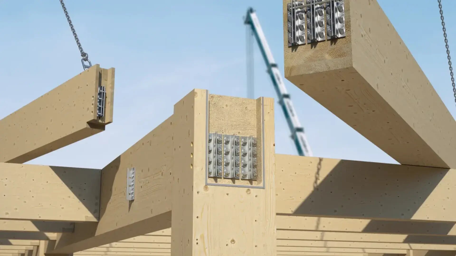 Große Holzbalken mit Metallverbindern werden auf einer Baustelle zusammengebaut. Im Hintergrund ist vor einem strahlend blauen Himmel ein Kran zu sehen. Die Balken sind mit vorinstallierten Metallplatten für eine sichere Verbindung versehen.